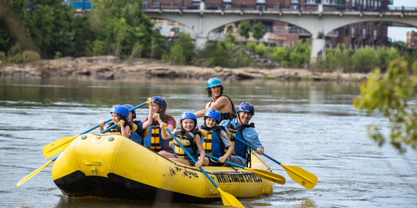 group of people white water rafting