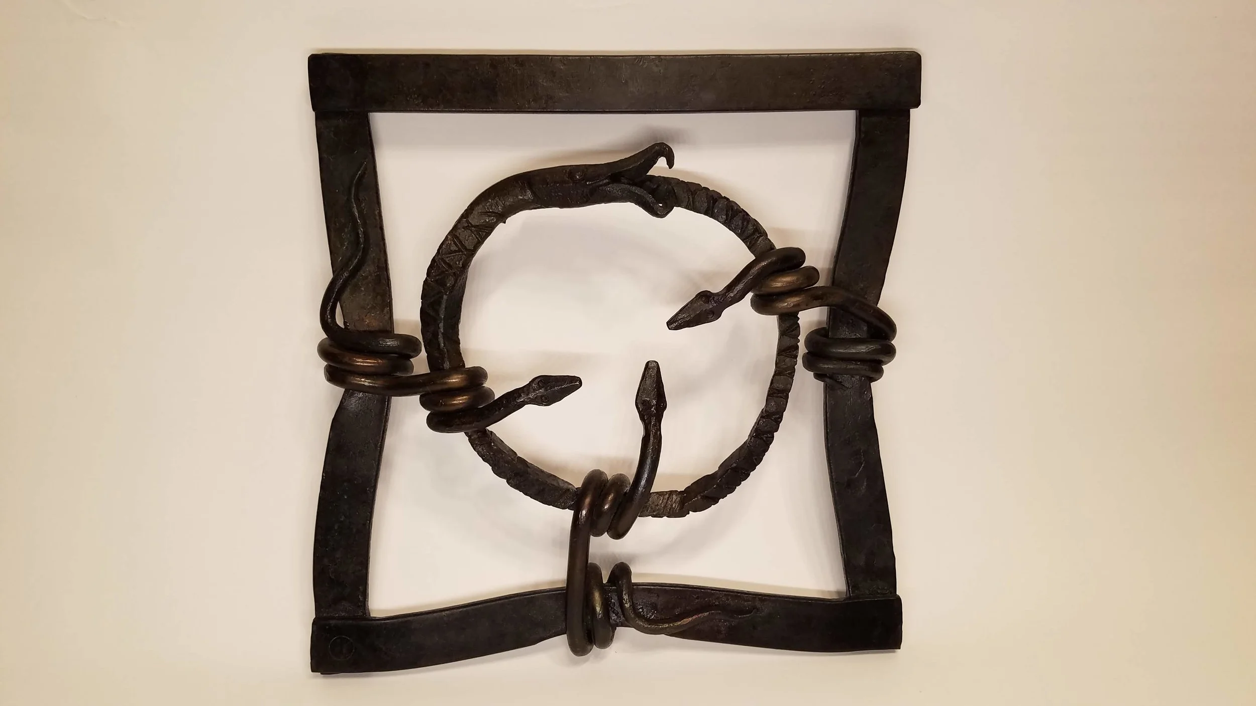  Hand forged ouroboros held by lesser snakes crushing the frame as they try to contain the snake.  