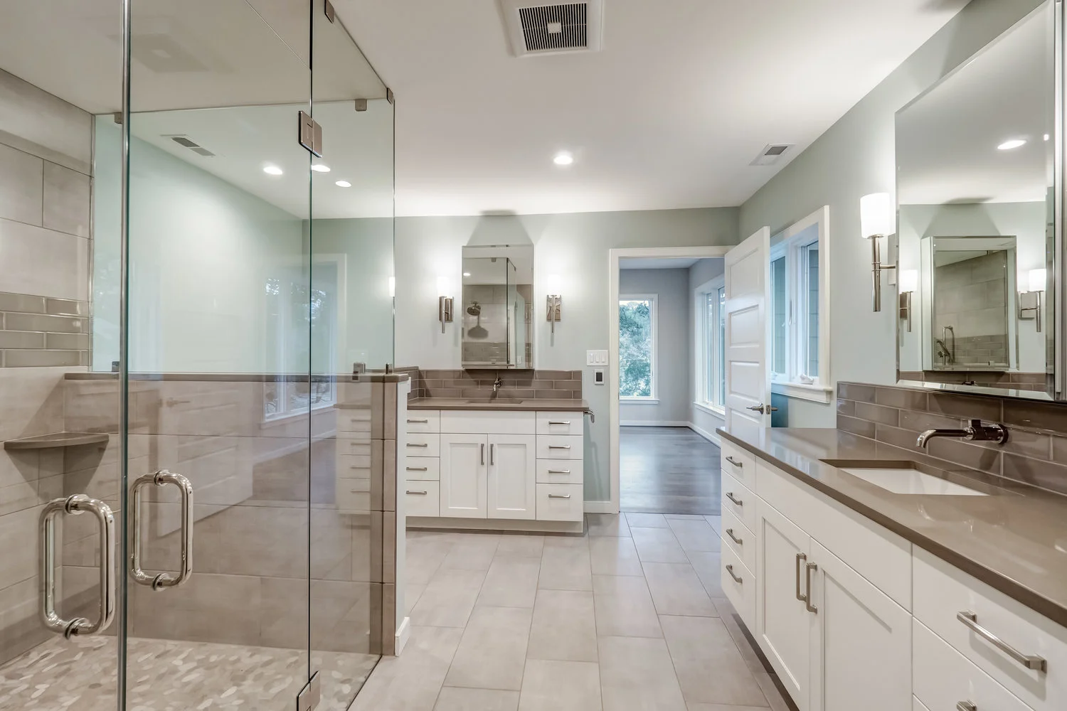 Master bathroom with separate his and her sinks and large shower with glass doors