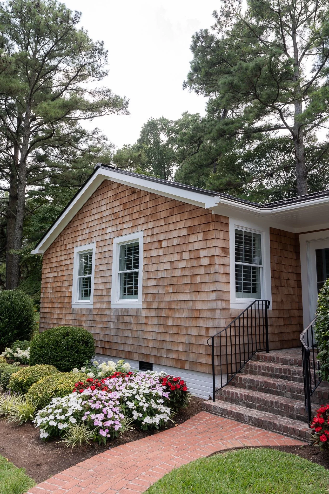 Front door and front of house with western red cedar siding and black metal roof