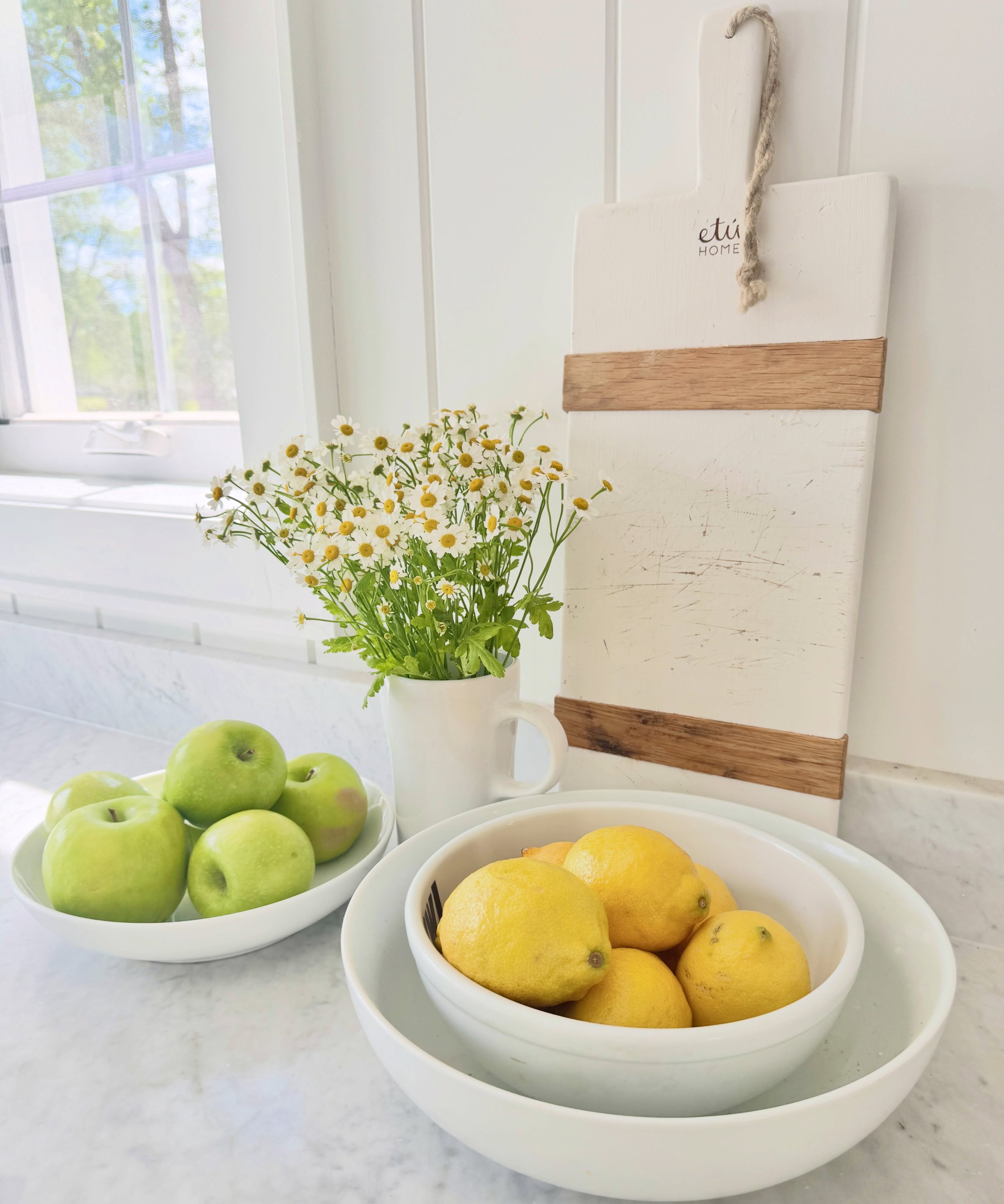 Nothing like a little cheery bunch of chamomile in a white pitcher to brighten the kitchen at @white_brick_house_ #sunlit #whitekitchen #simplestyle #interiorstyling #interiors