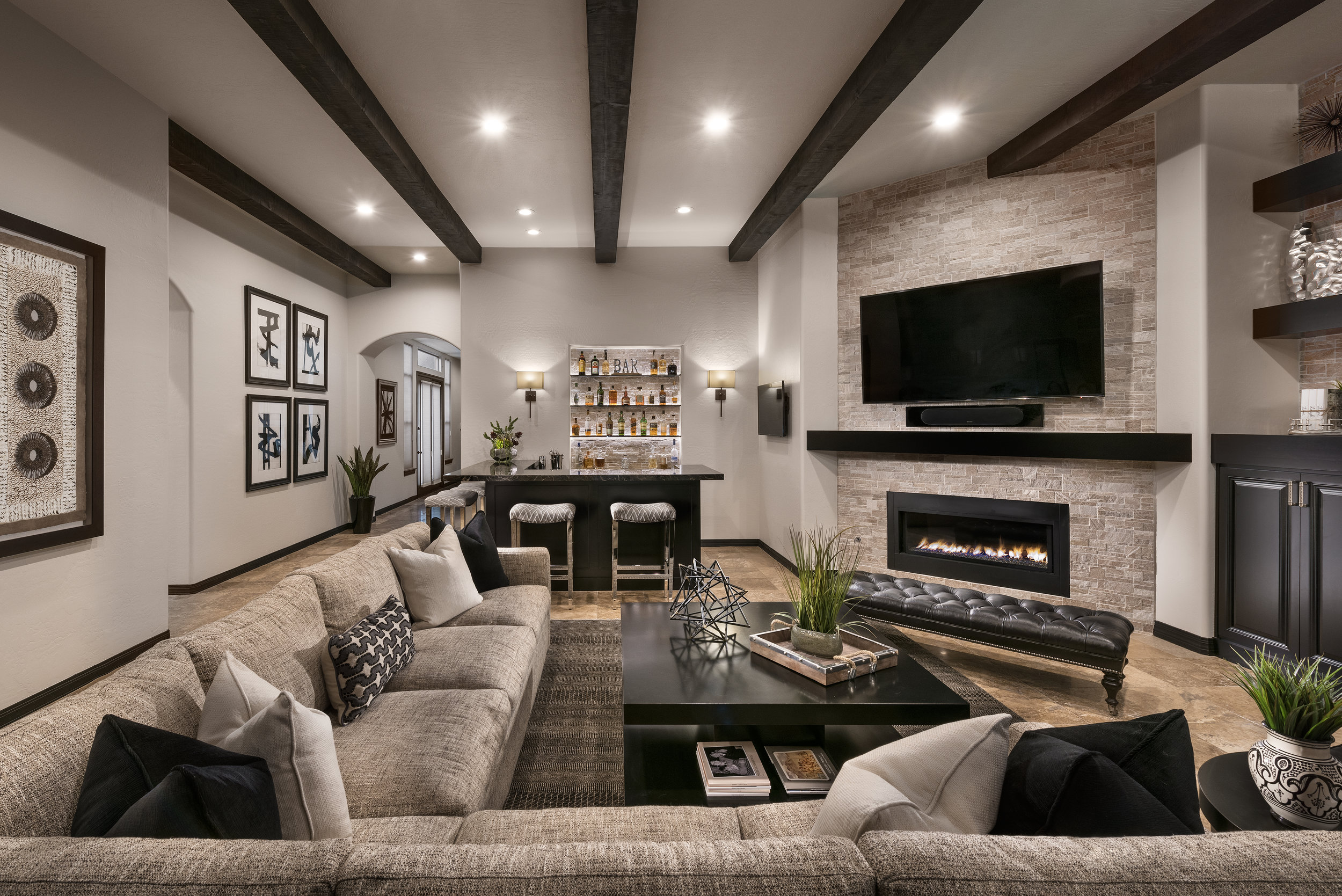 Family Room After Photo. With emphasis on the newly built bar as well as beam detail on ceiling, fireplace and overall design of the space.