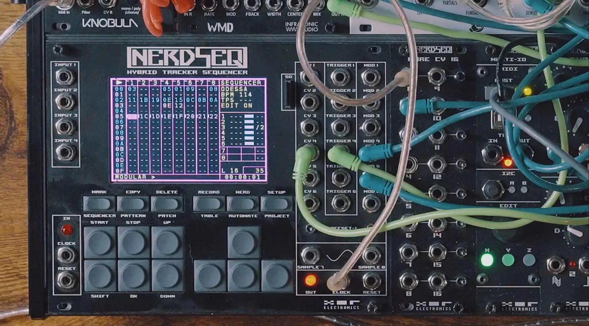 NERDSEQ sequencer screen showing separated groups of patterns, with the patched CV and trigger expanders beside it.