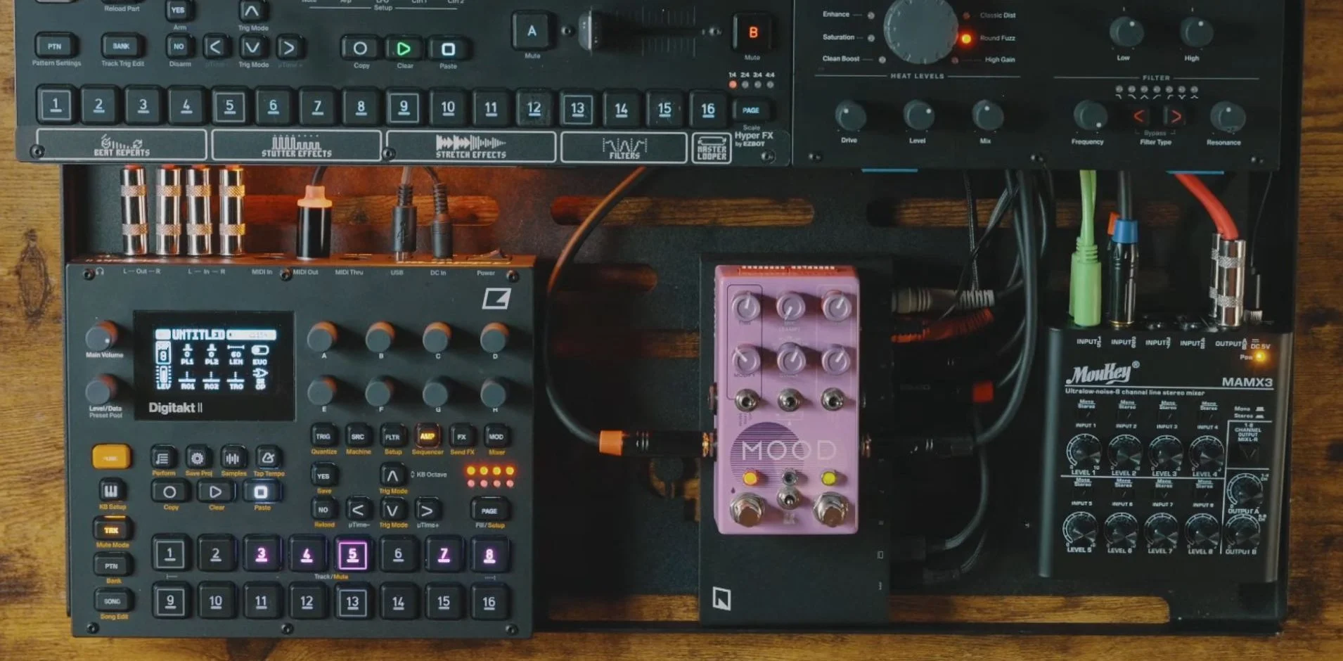 Digitakt II, MOOD MKII, and a compact summing mixer with their audio cables connected beneath Octatrack and Analog Heat +FX.