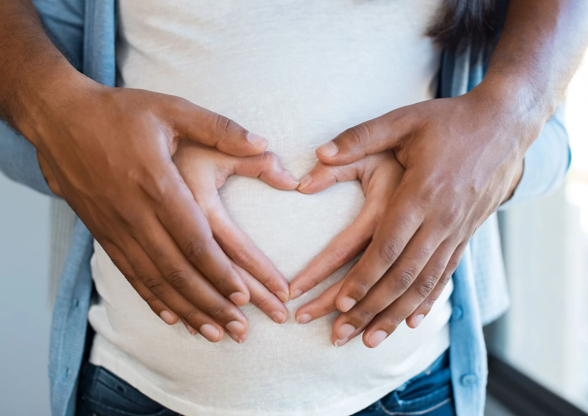 hands holding pregnant belly