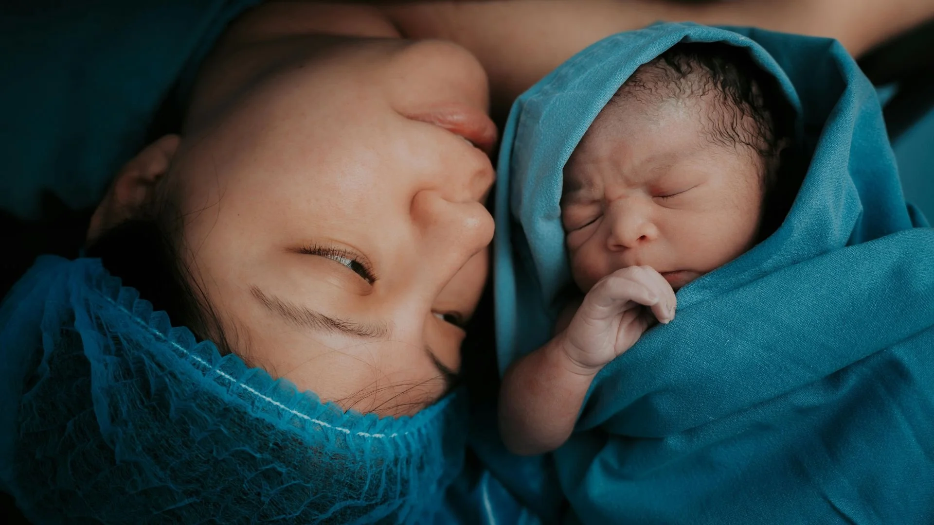 mother holding her baby during cesarean