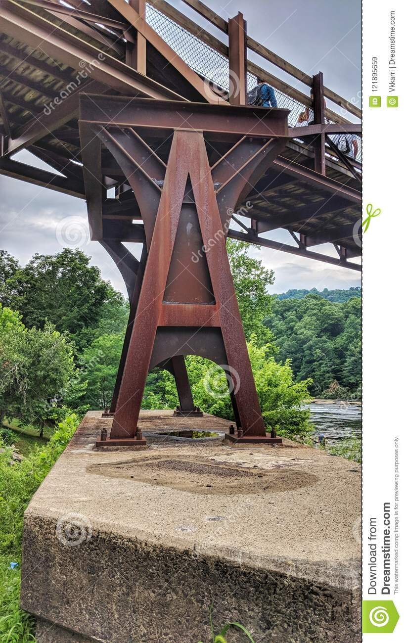 architecture-metal-rustedstructural-support-beans-under-bridge-support-beam-concrete-pad-under-ohiopyle-pennsylvania-pedestrian-121895659.jpg