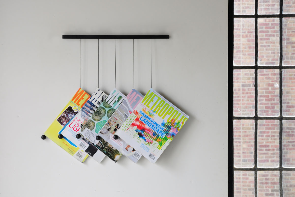   Magazine Hanger by Isaac Yu Chen  This design reduces the act of displaying magazines to the object itself and string. In a gesture similar to inserting a bookmark, magazines are hung on their own weight, creating a graphic display. 