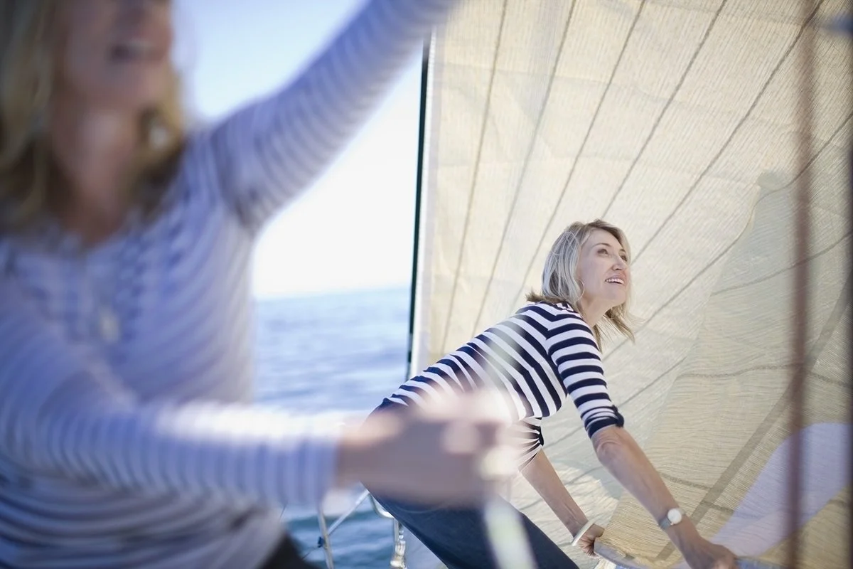 Women adjusting sails on boat