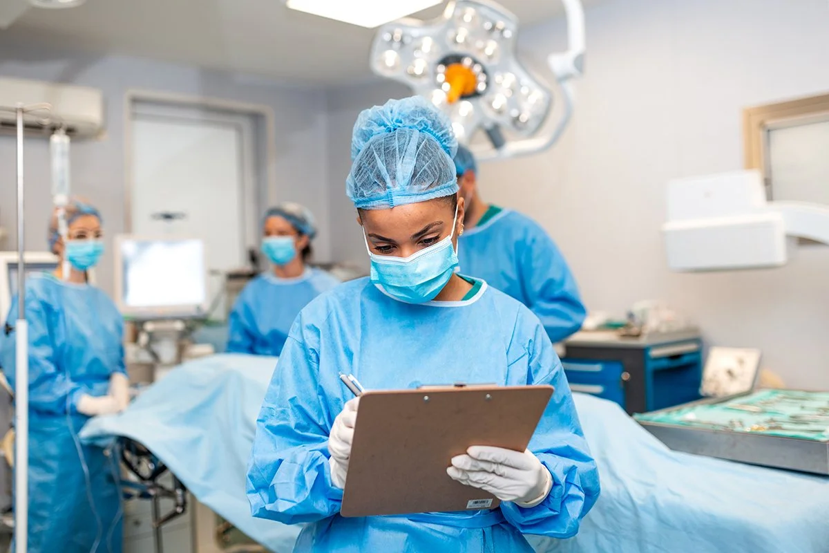 Doctor taking notes on clipboard in surgery room.