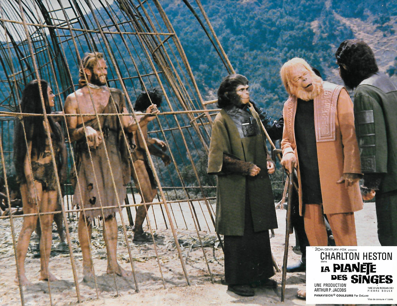  In this French lobby card, sympathetic chimpanzees Dr. Zira (Kim Hunter) and Dr. Cornelius (Roddy McDowall) bring Dr. Zaius (Maurice Evans) to see the human (Charlton Heston) they call “Bright Eyes”, who appears to be much more intelligent than the 