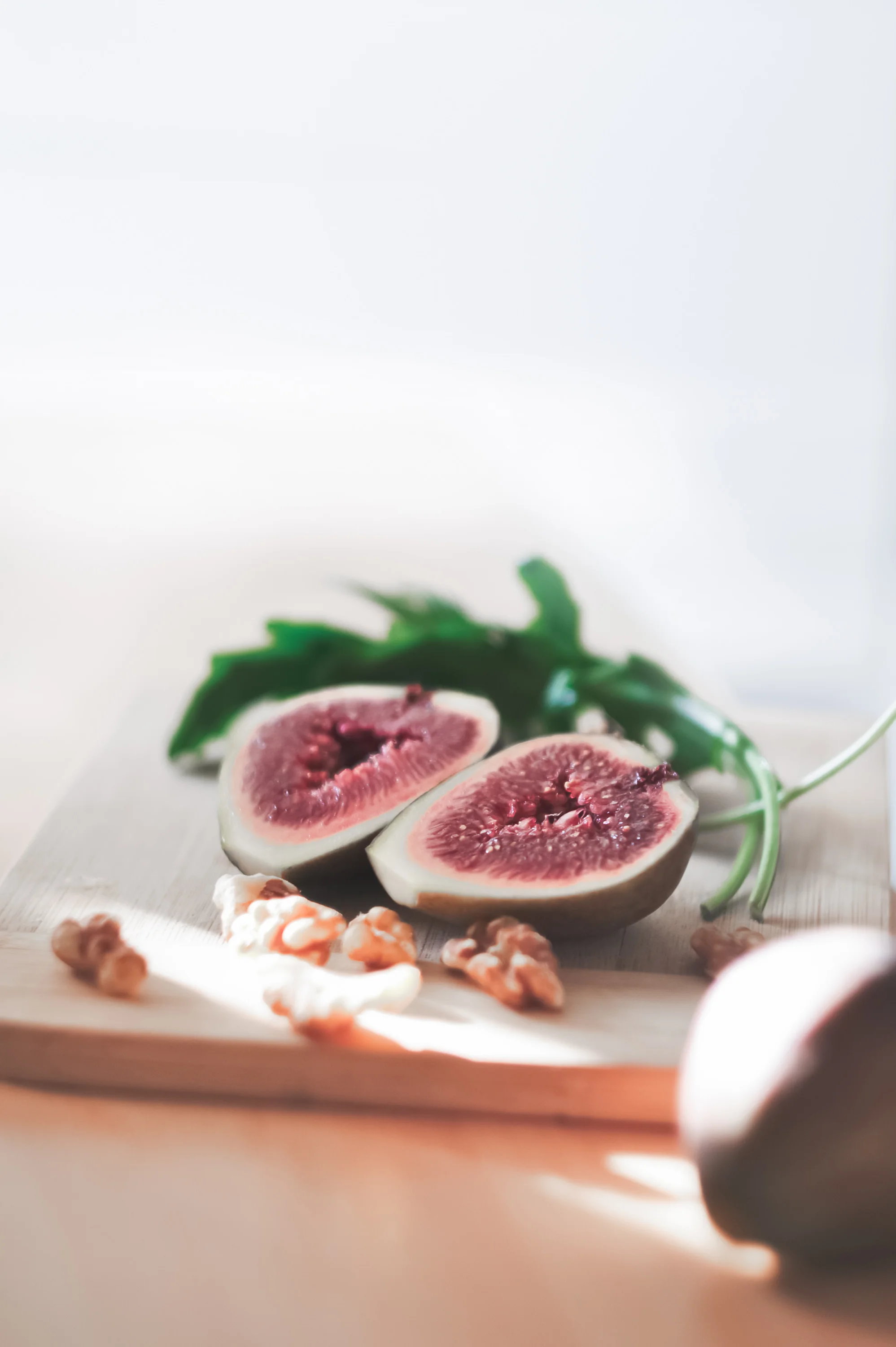 chopping board with figs, walnuts and rocket