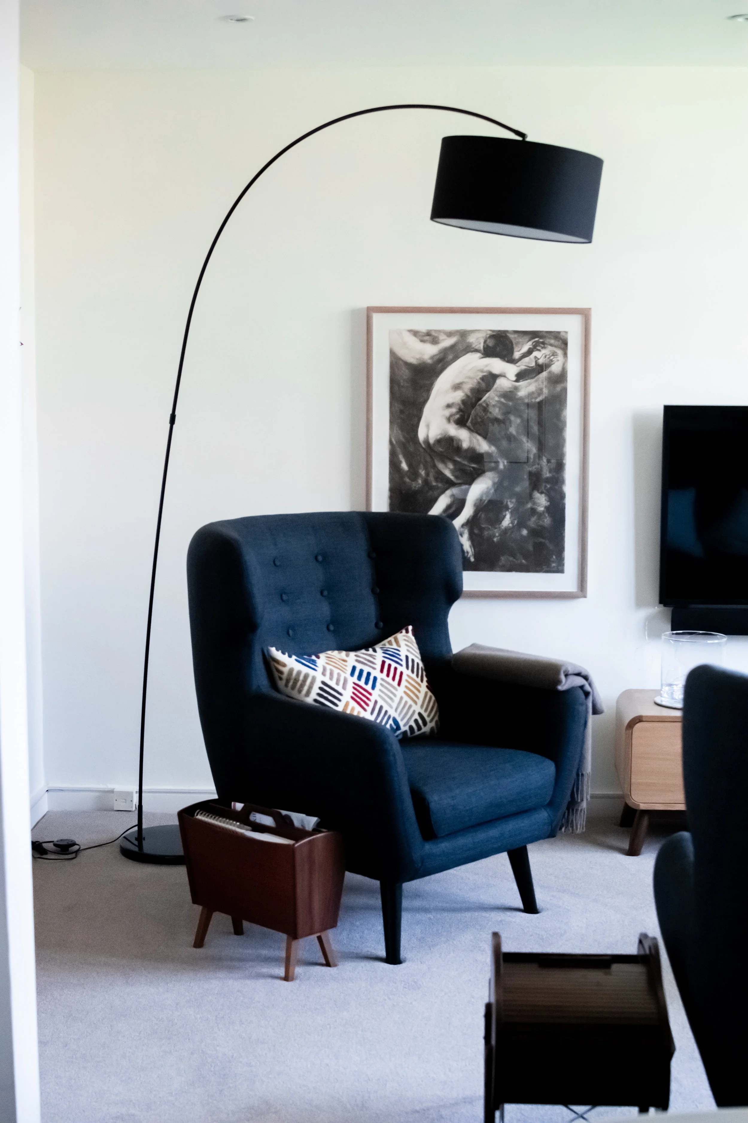 Navy blue armchair with lamp, art and mid-century accessories