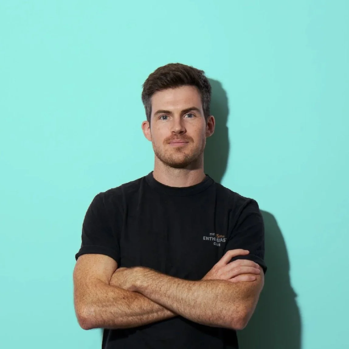 Portrait of Matt Madden with his arms folded on a light blue background from Matt Madden Visuals