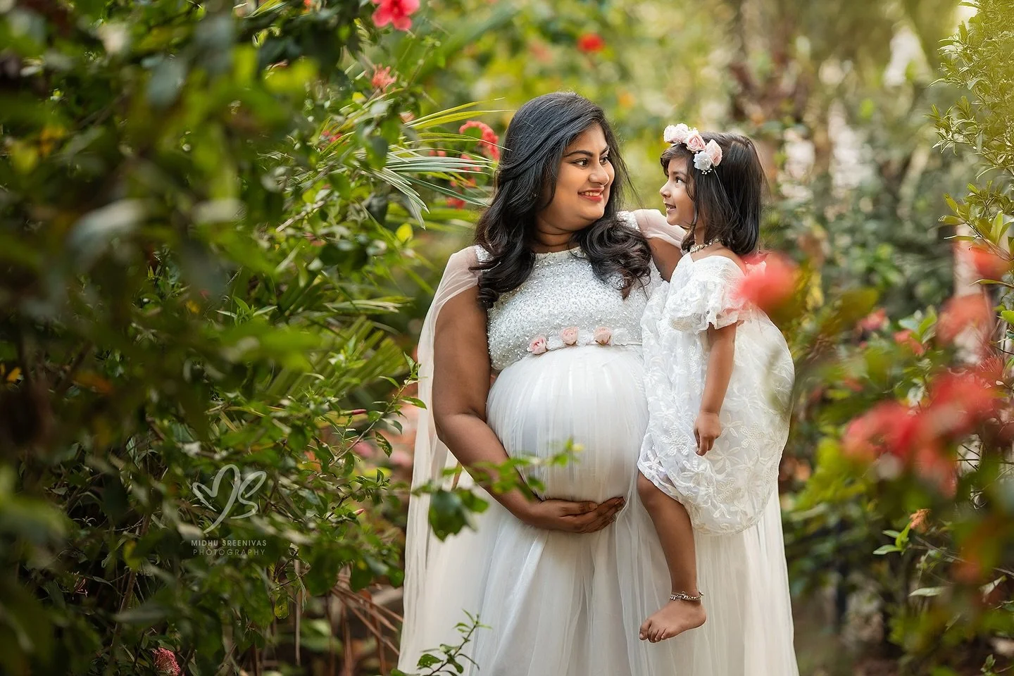 One hand holding her first miracle, the other holding her next. 😇