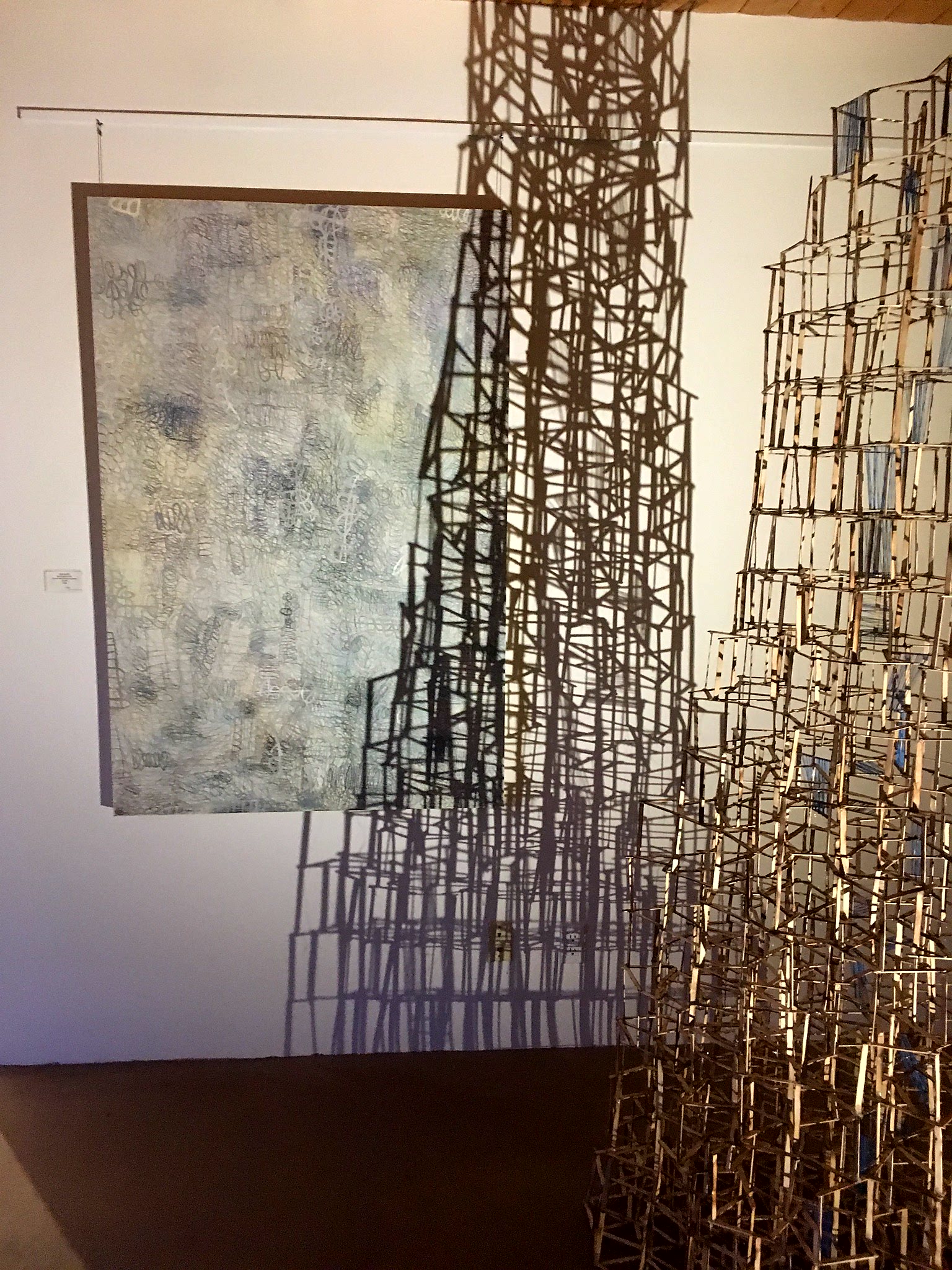 tower with cerulean sky, 2018, popsicle stick sculpture with cerulean blue thread, cast shadow drawing. Shown in gallery with Blair Vaughn-Gruler painting