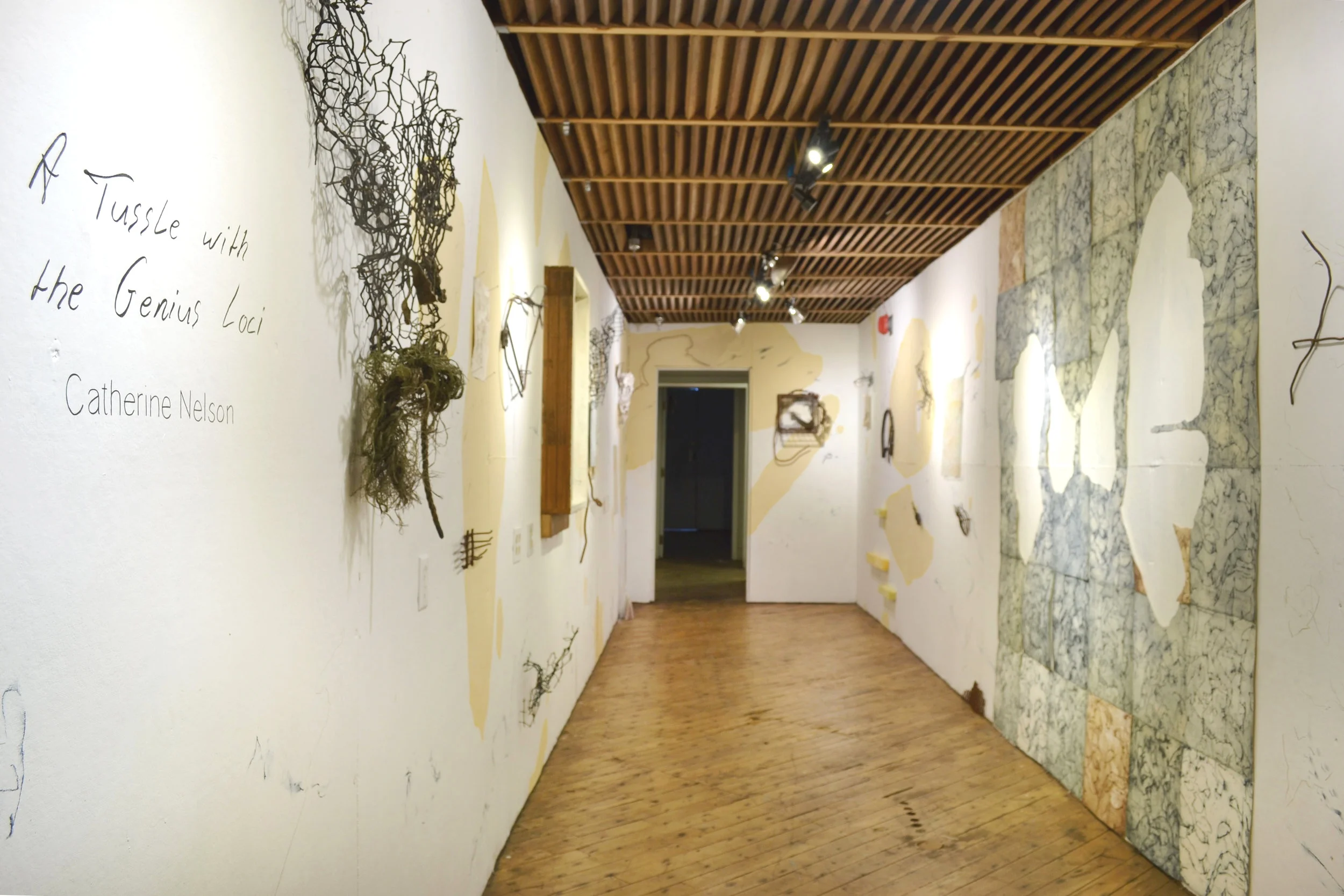 Nelson’s installation, composed with tea-dyed collagraph prints, steel collage sculptures, found objects, drawings on glass, papier mache, surface prints from the bayou, and direct wall drawing
