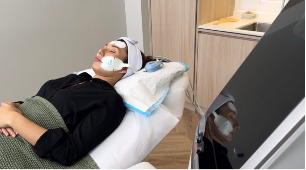 Patient at LYFE Clinic receiving a needle-free EMFACE® facial lift treatment.