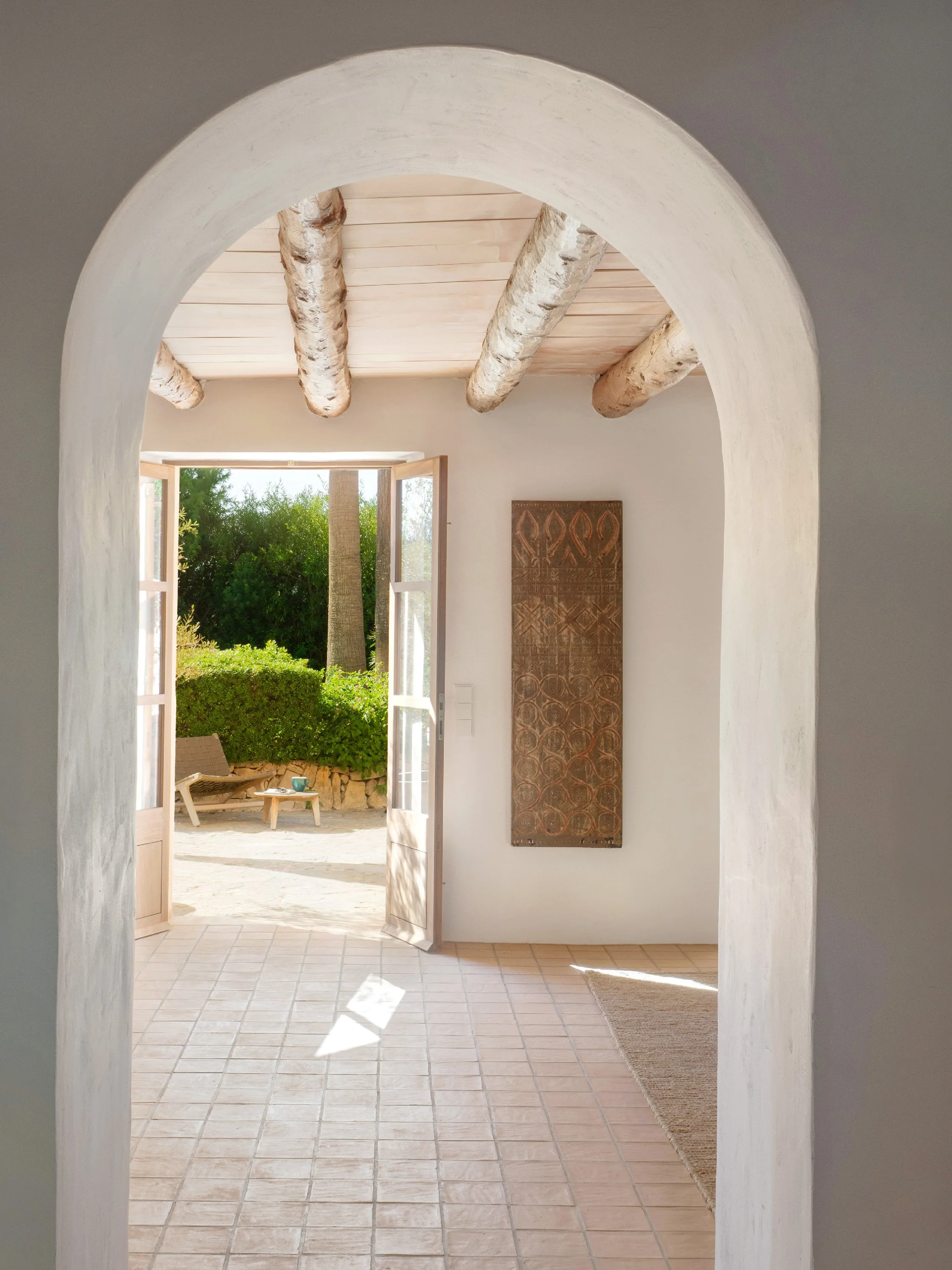 Arched doorway through historic finca. Terracotta floors. Timber beams. Renovation in Felanitx Mallorca