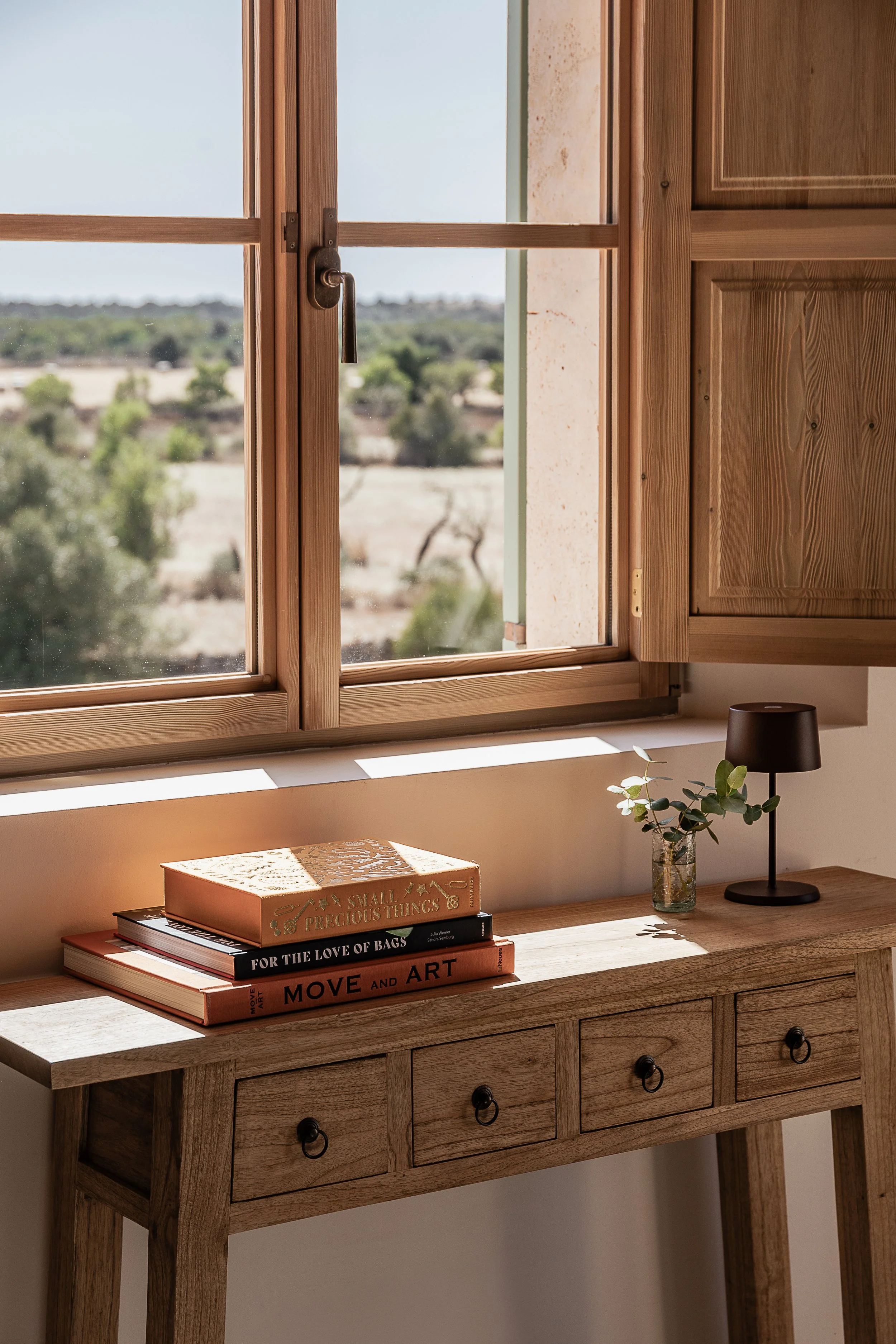 Oak-framed window overlooking the Mallorcan countryside, bringing natural light and landscape into a Mediterranean home.