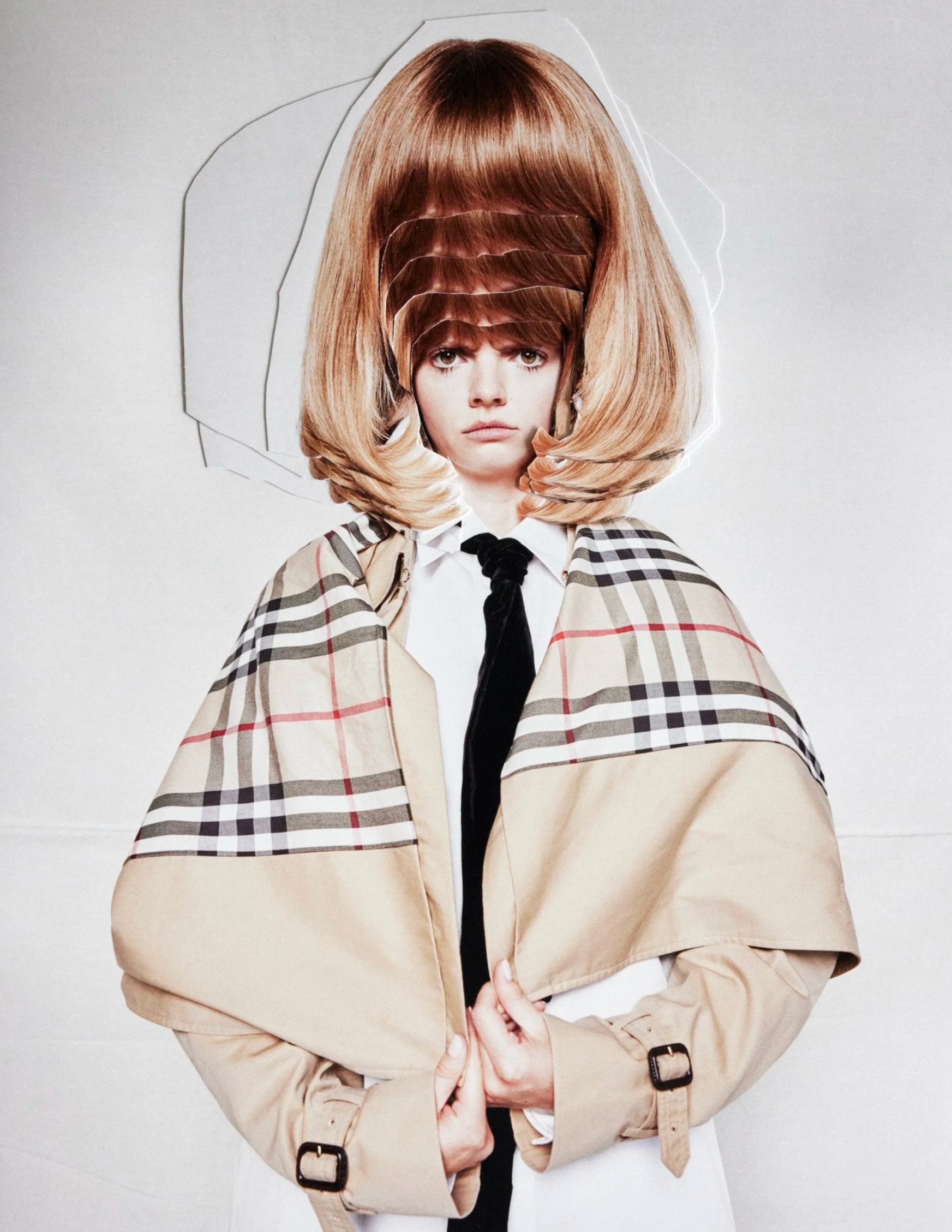 Cutout collage style image of a person with multiple layers of hair and a beige trench coat, standing against a plain background.