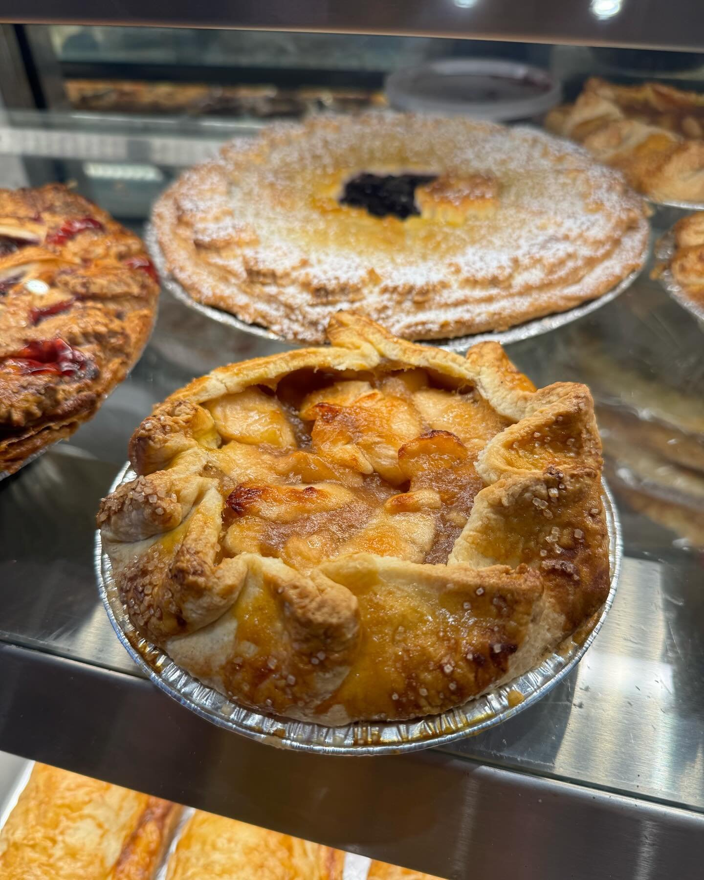 Reminder we&rsquo;ve got pies available in a bunch of flavours and sizes! In addition to Today&rsquo;s Special: Coconut Cream, pictured is one of our classic Apple galettes! (With a larger Wild Blueberry pictured behind) 🫐 🍎 

Reminder our storefro