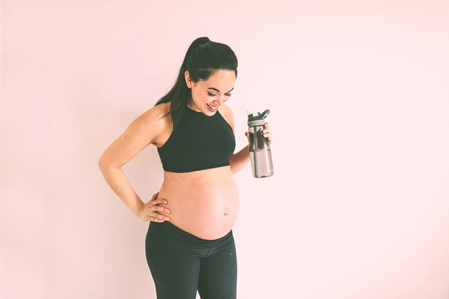 pregnant mom drinking water and exercising