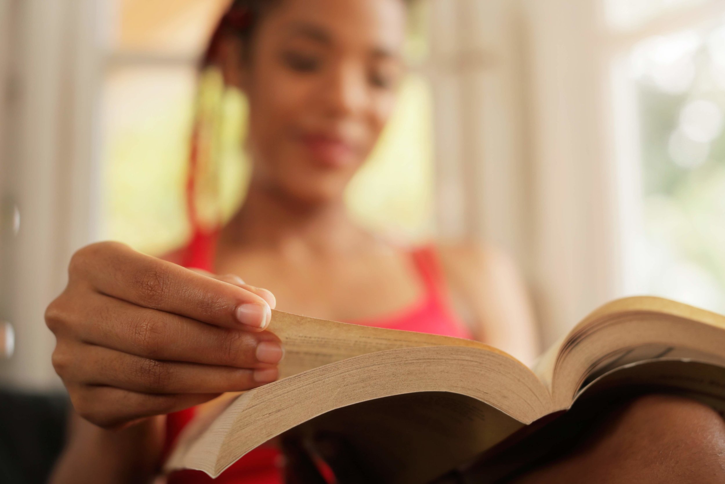 african-american-woman-reading-book-at-home-focus-PYWUU5Y.jpg