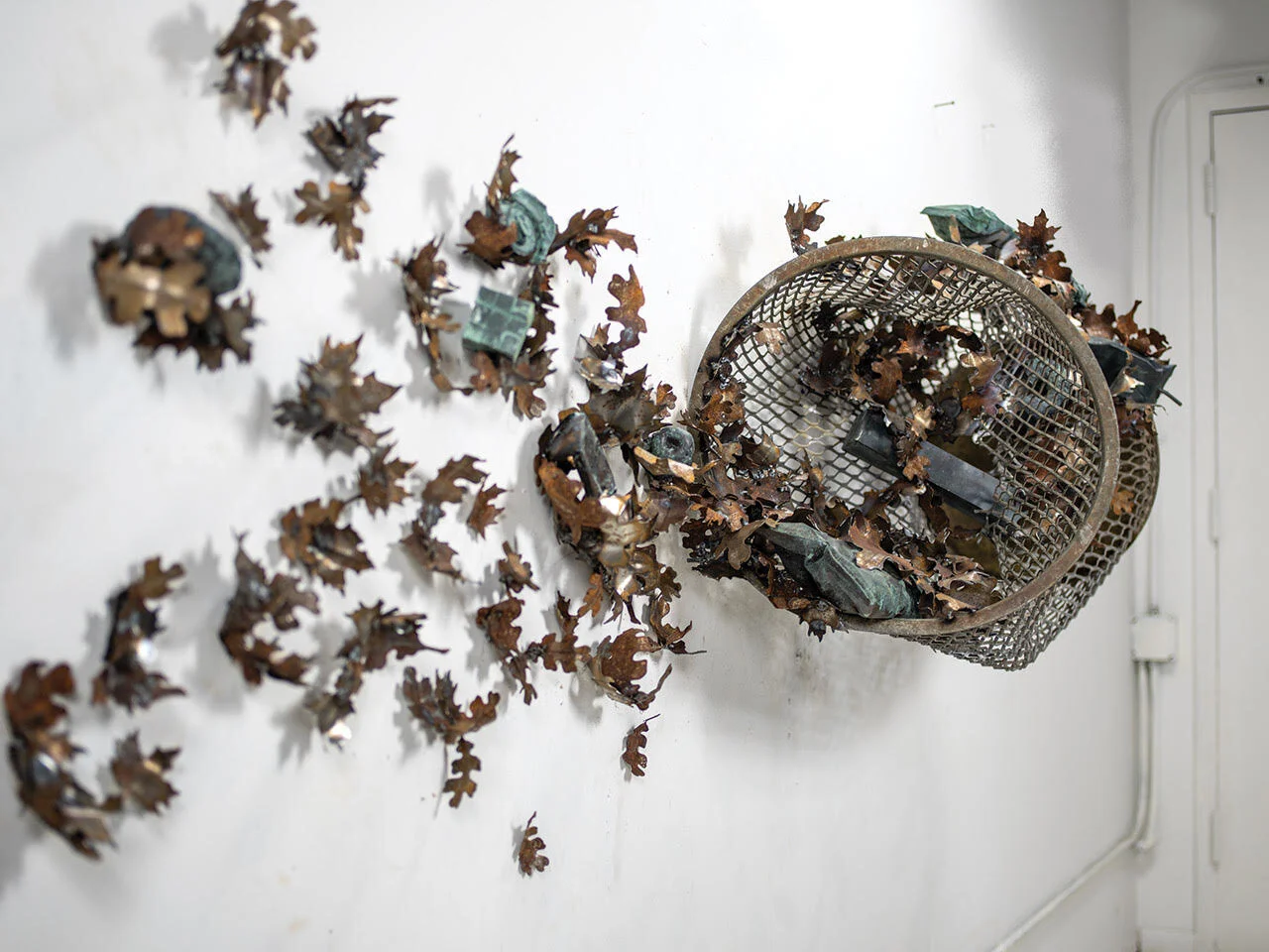 Swirling mass of steel can, scattered leaves, and refuse by Sam Tufnell.