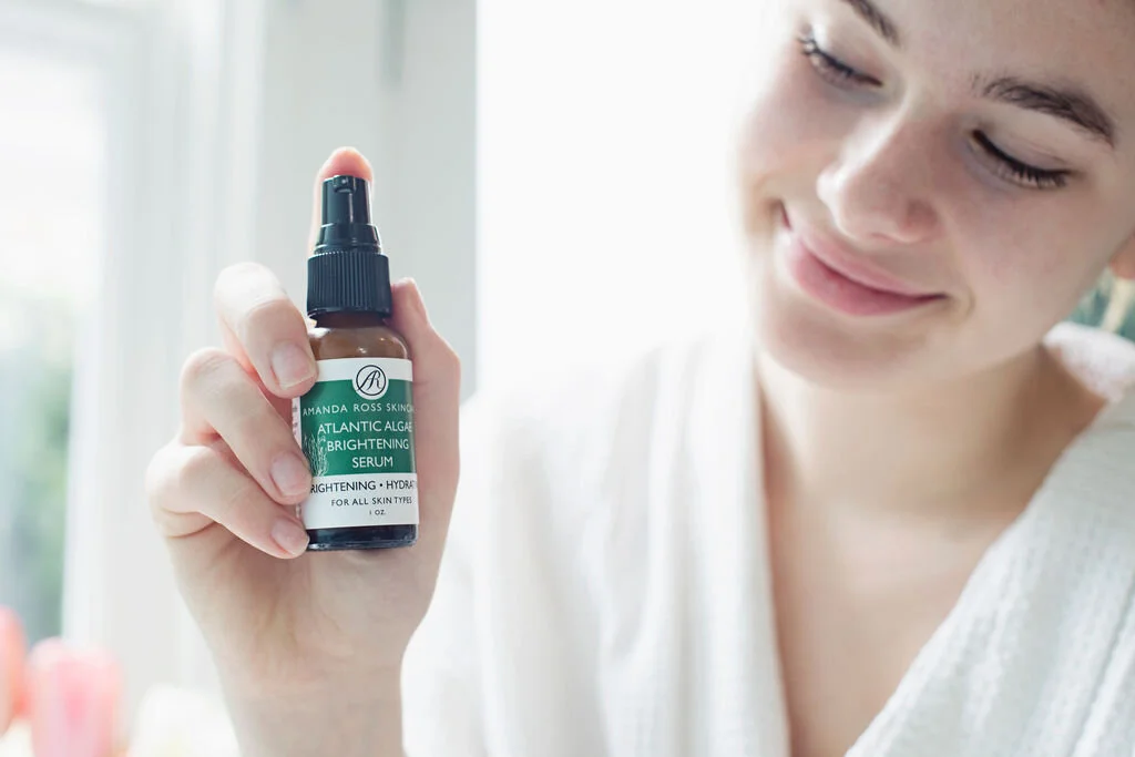 Model Holding Atlantic Algae Brightening Serum Amanda Ross Skin Care is organic, natural, family owned, and made with love.