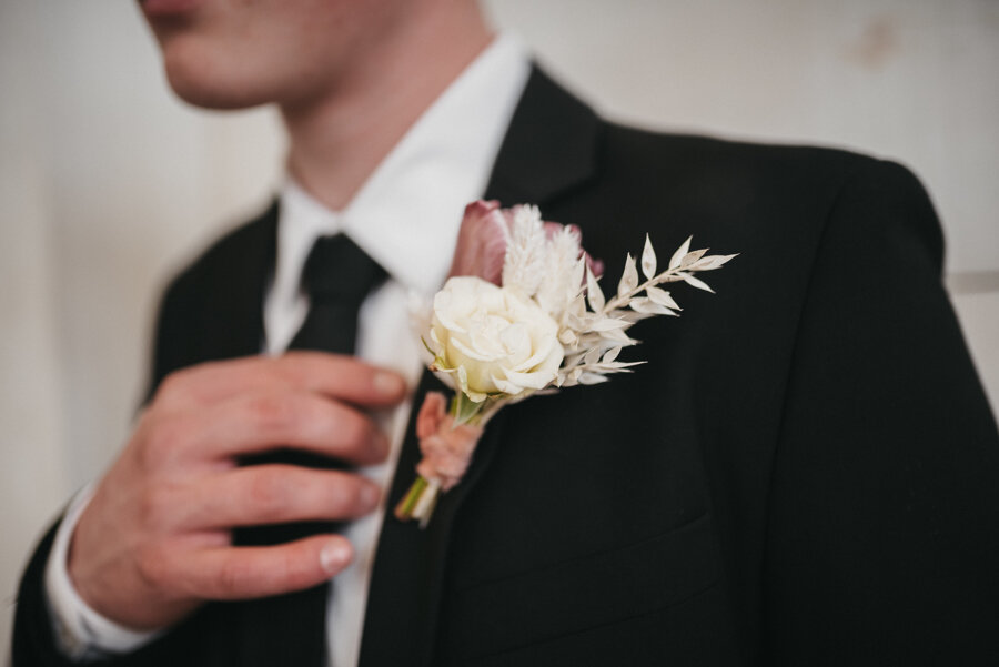  Logan, Utah’s Sweet Afton Floral creates classic white and mauve wedding boutonniere for this groom’s suit. black wedding suit, black wedding tie, classic men’s boutonniere, mauve and white wedding colors, mauve and white wedding florals, profession