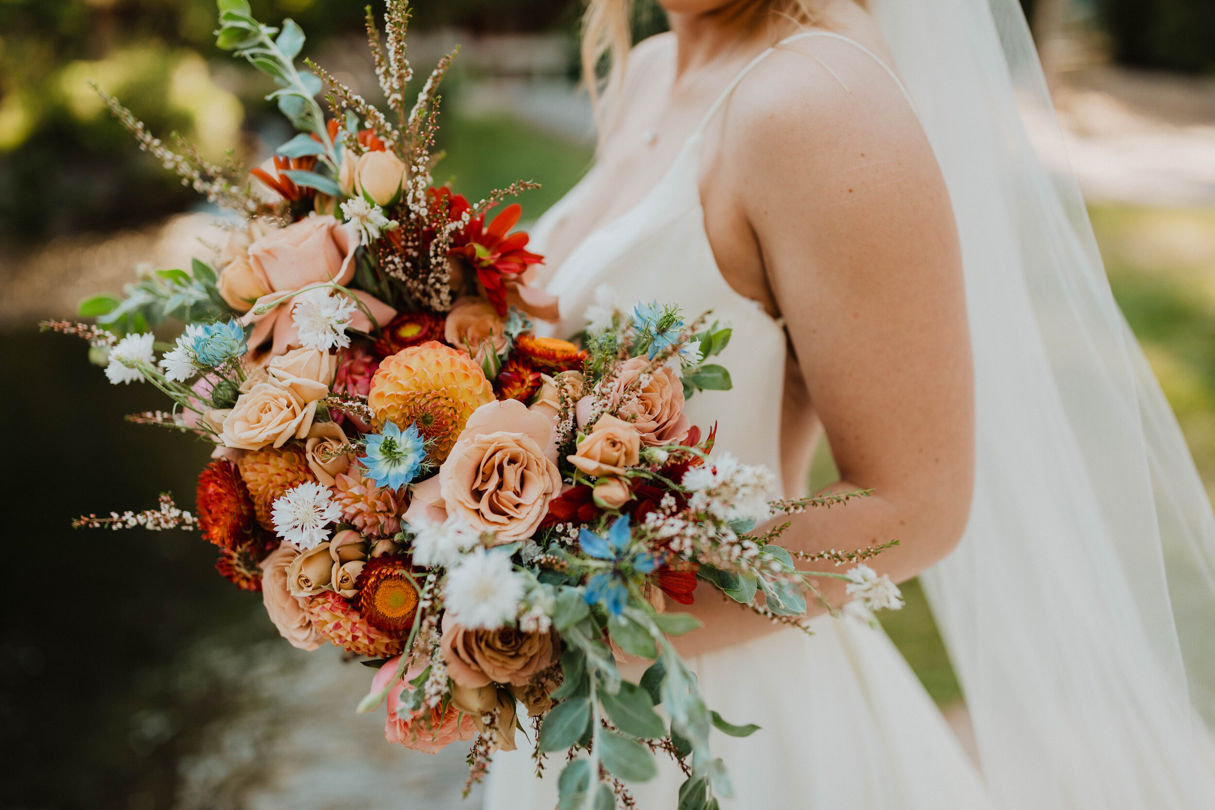  This modern-styled Logan, Utah bride flaunts a Sweet Afton Floral custom wedding bouquet. turquoise and rust colored wedding bouquet, bohemian colored wedding bouquet, stream line modern v-neck open back wedding dress, long wedding bridal veil, prof