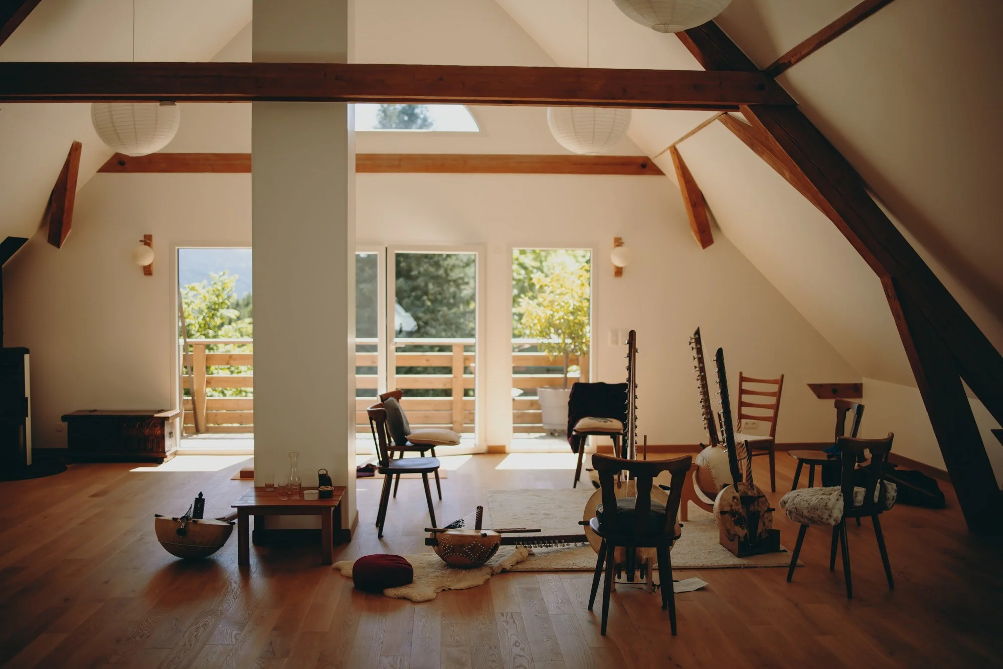 Koras arranged for a workshop led by Josh Doughty in eastern France near Colmar, set in a bright attic space with wooden beams and natural light, ready for students to learn traditional West African music.