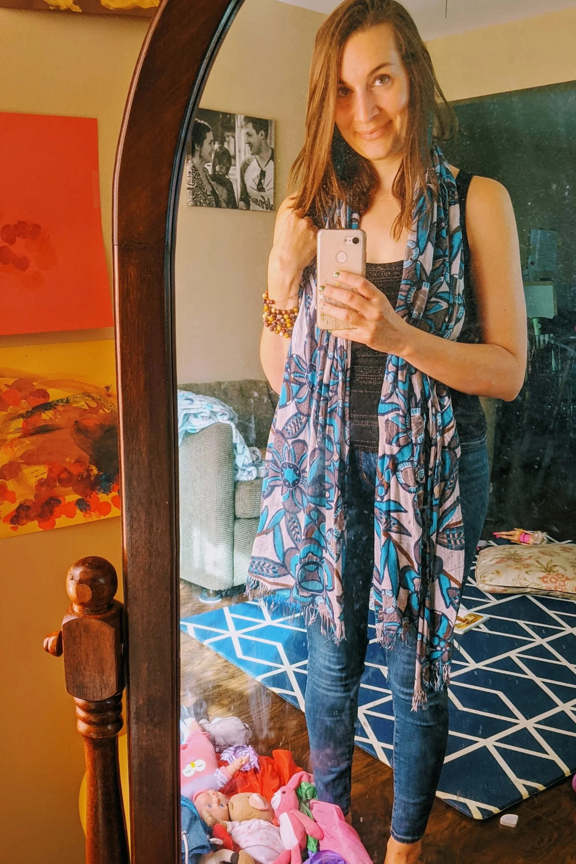 selfie in a dirty mirror, surrounded by a mess of kids toys and with back and white family photo in the background
