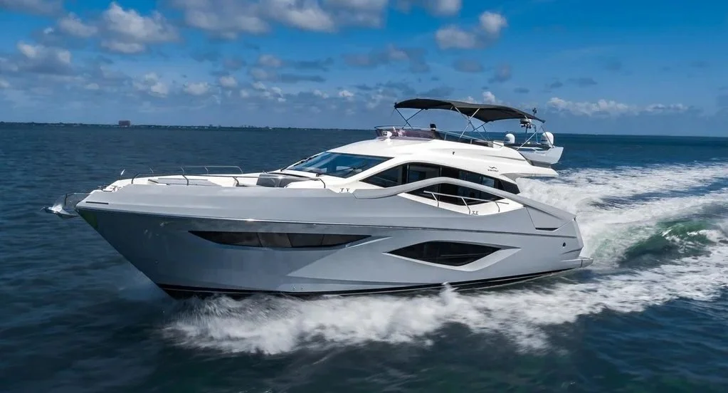 Two luxury yachts cruising on the ocean under a partly cloudy sky.