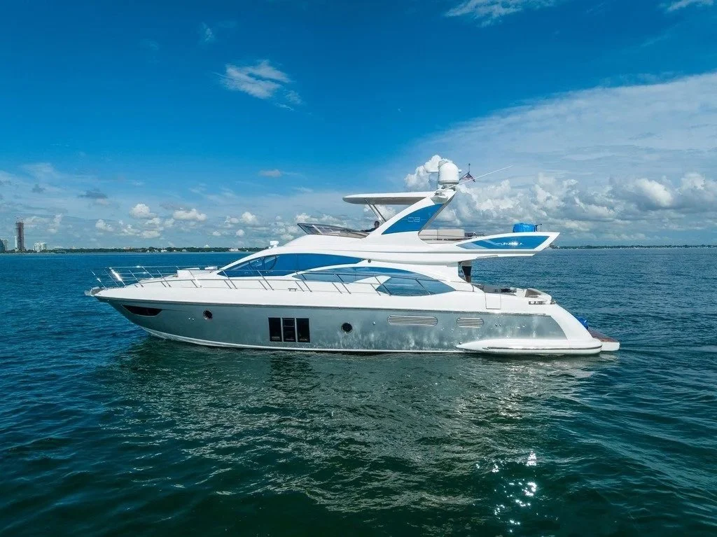A luxurious white yacht cruising on calm waters under a partly cloudy sky.