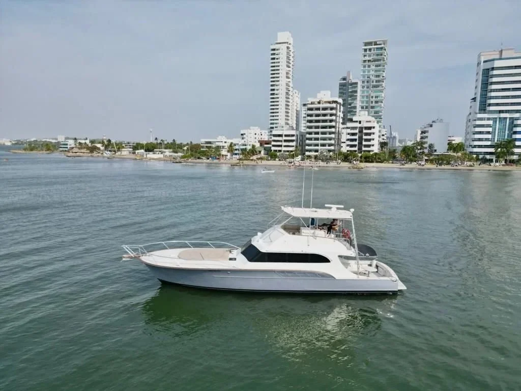 Motor yacht on water with city skyline in background
