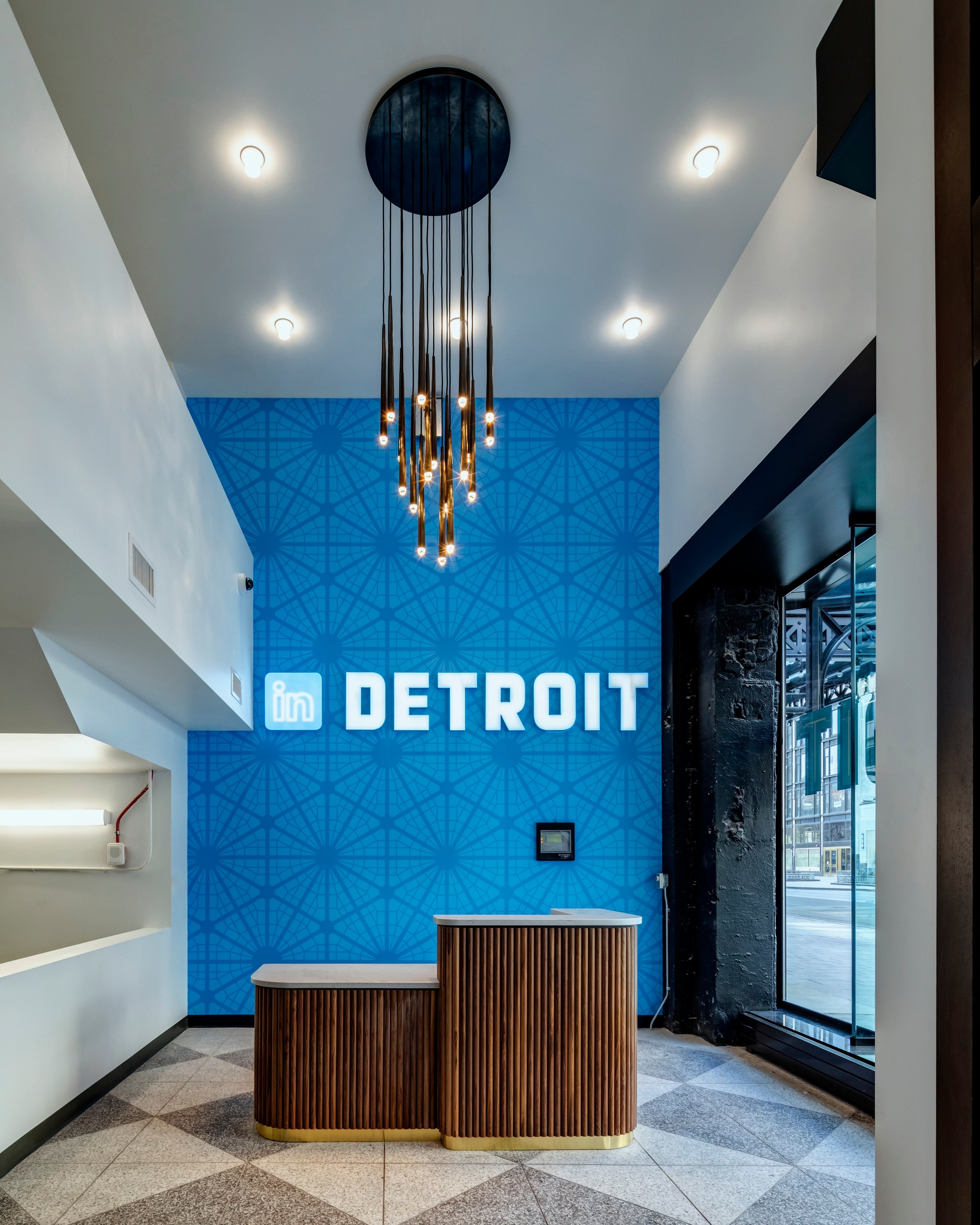 As the plan changed for the main reception to be on the second floor, the ground floor entry was simplified to a simple wallcovering based on the initial pattern and a faux neon sign.
