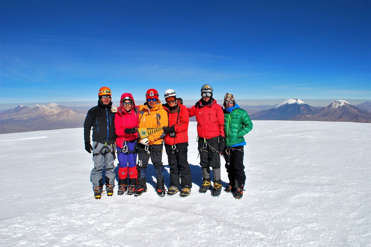  Group of climbers on the summit of Sajama volcano, with Parinacota and Pomerape in the background. Bolivia. 