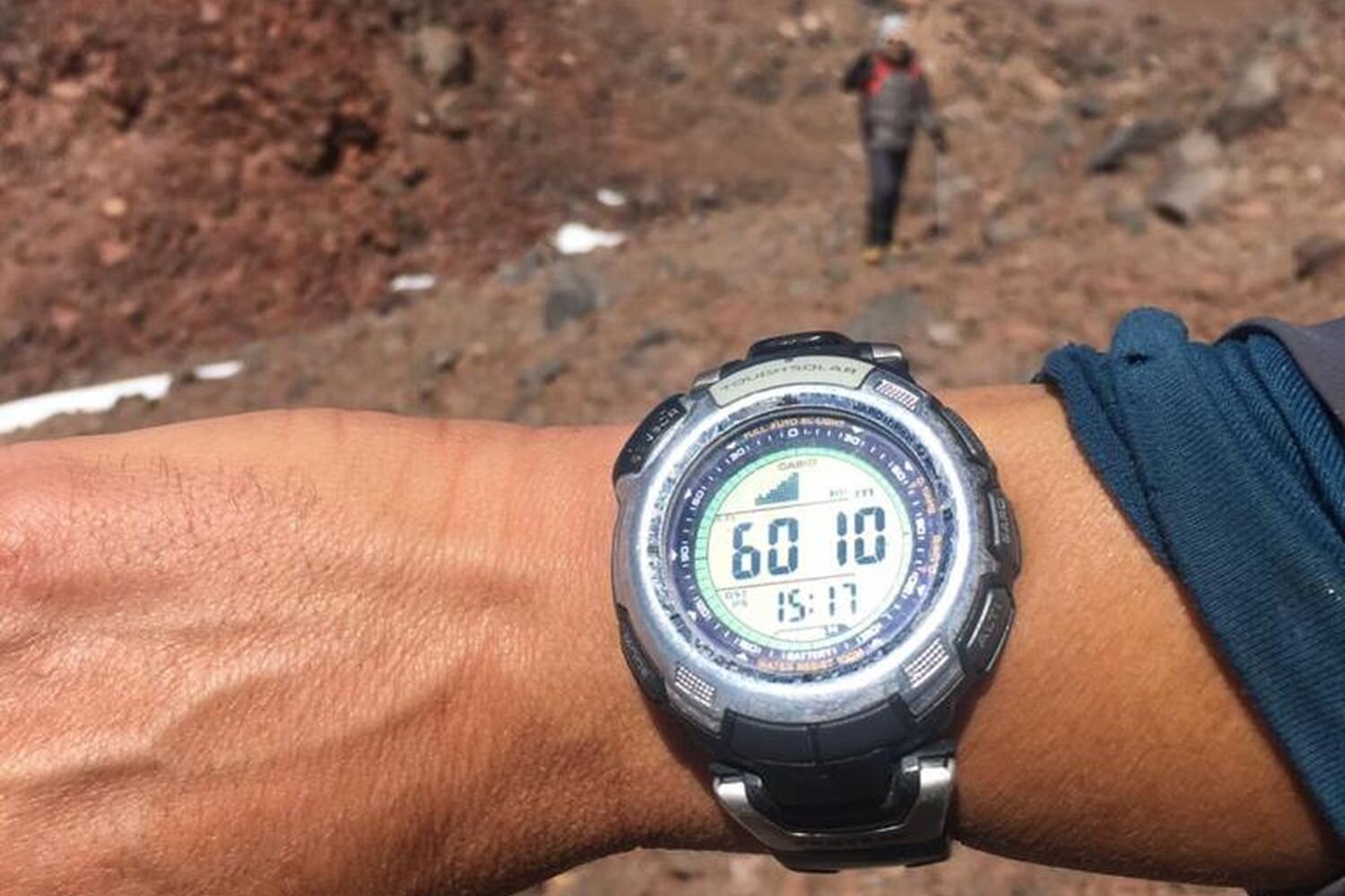  A guide shows the altitude on his watch, a few meters below Pili volcano summit. Chilean Altiplano. 