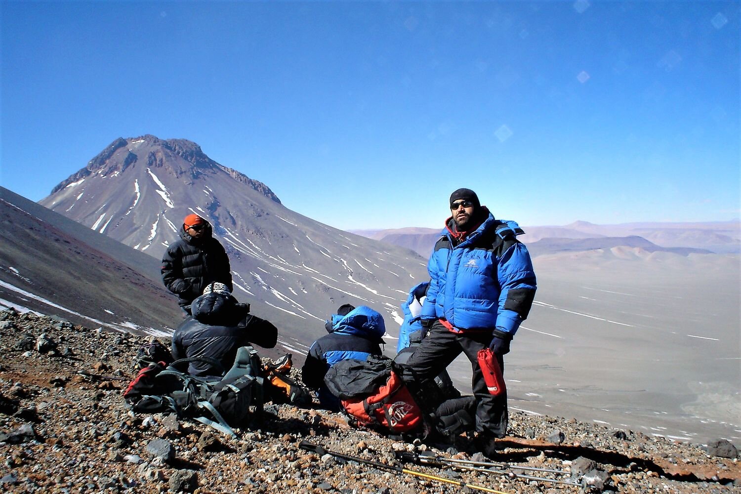  Mountaineers resting near the crater of Lascar active volcano, with Aguas Calientes volcano in the background. Atacama, Chile. 