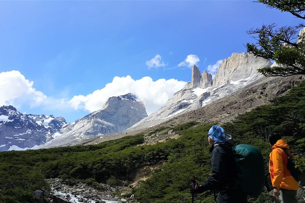  Hikers admiring the mountains and granitic peaks in the French Valley. Chilean Patagonia. 