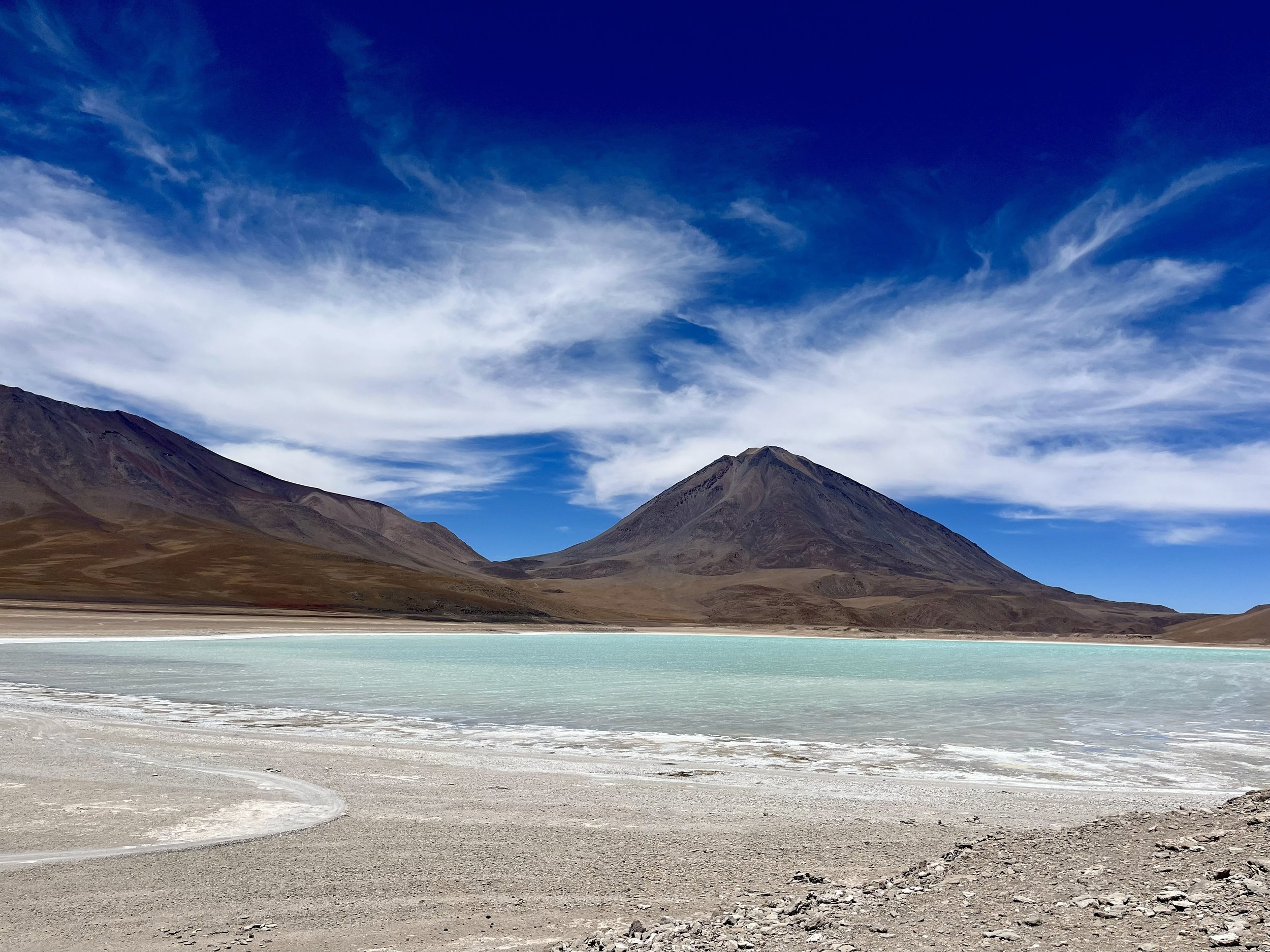 Turquoise high-altitude lagoon surrounded by volcanic peaks in the Atacama Desert, northern Chile.