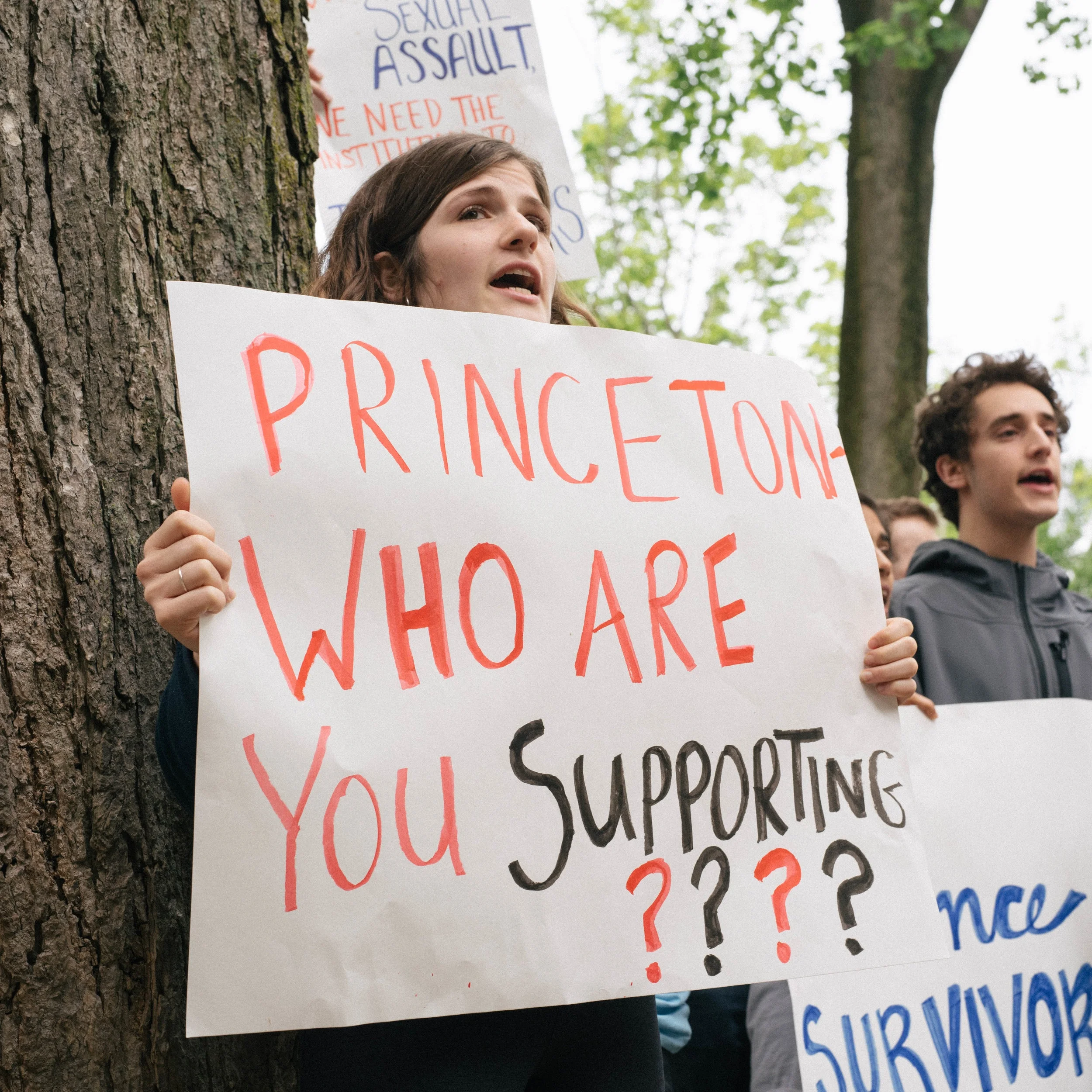 Photo by Elizabeth Yu ‘19. Student holding sign (“Princeton who are you supporting????”) and chanting.