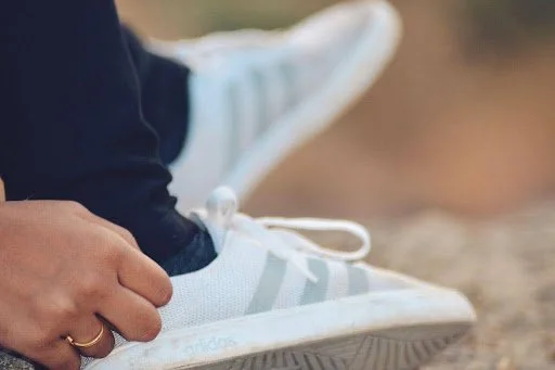 Close-up of an Adidas running shoe showing cushioning and lace structure for heavy runners needing proper support