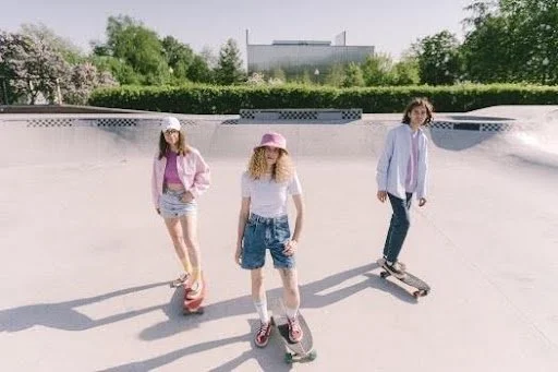 three young adults on skateboards