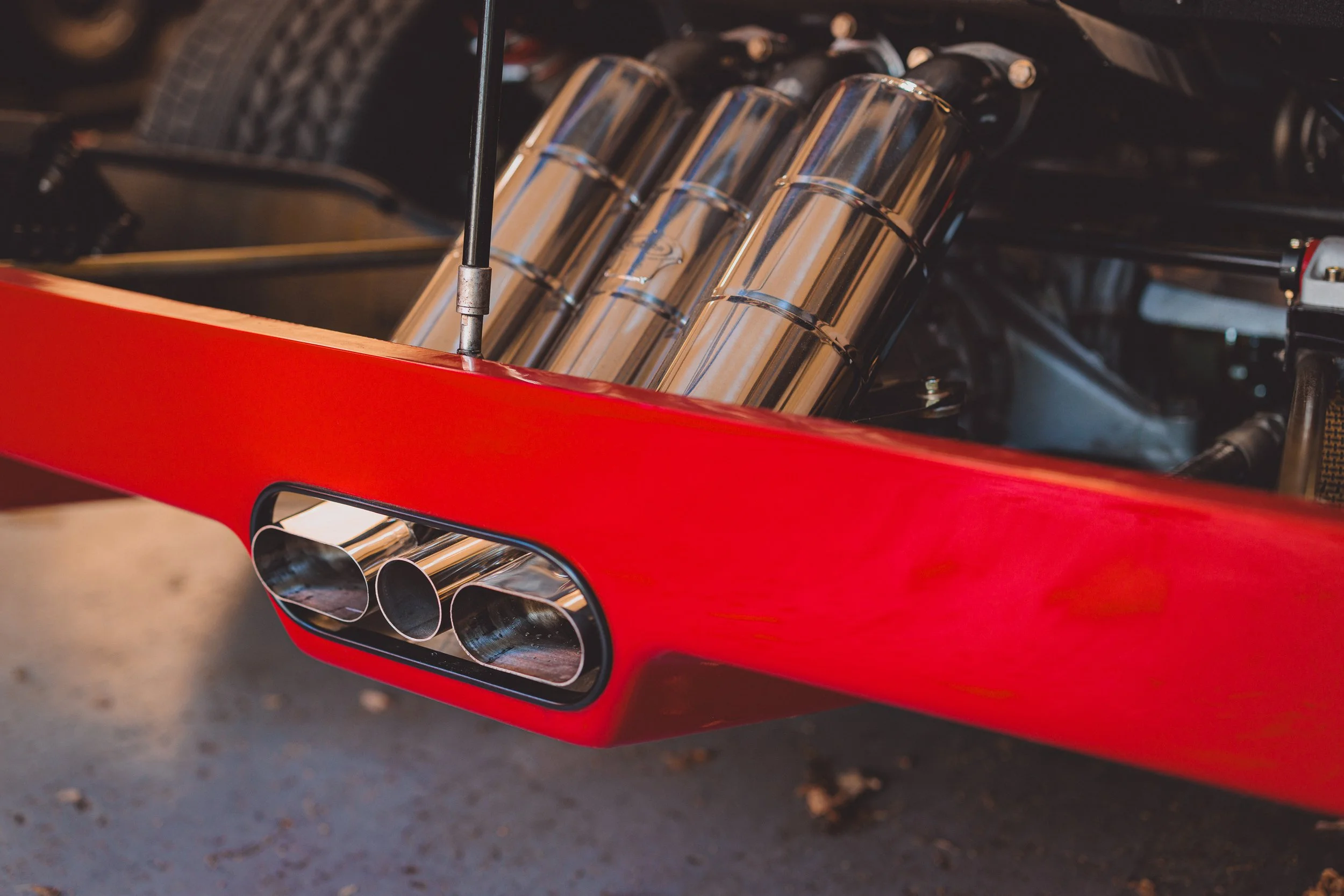Photograph of the F40 triple exhausts, including the engine bay open and being able to see the silences.