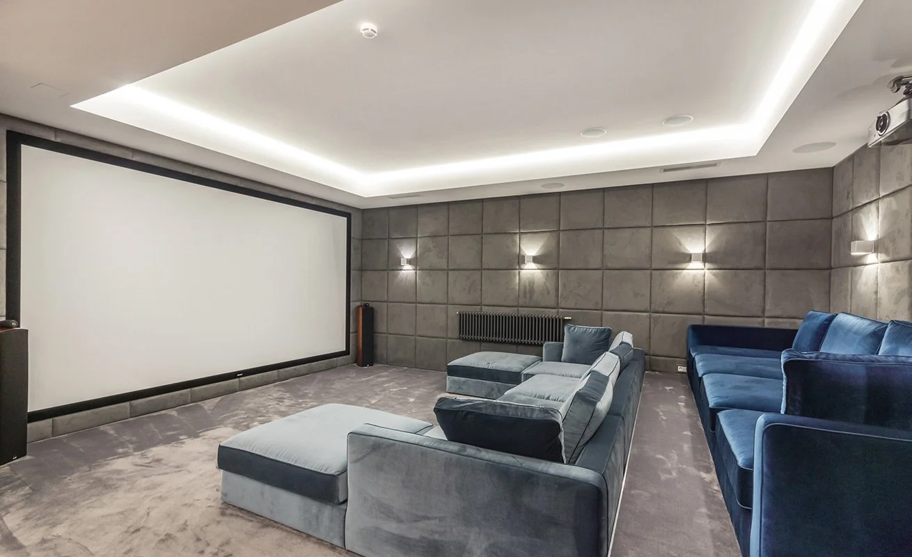 Custom home theater in Spartanburg featuring a large projection screen, surround sound, and comfortable seating.