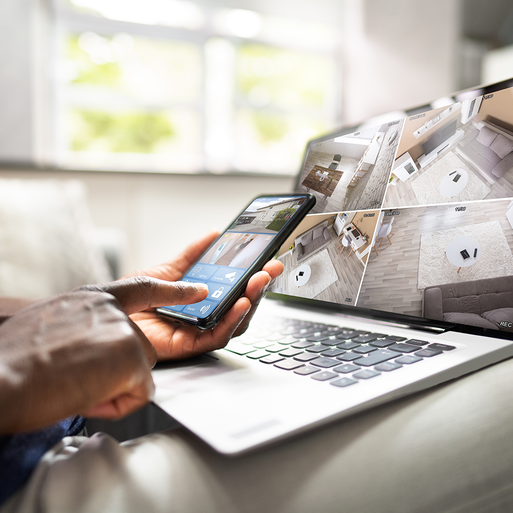 Security camera feeds monitored from a laptop and smartphone.