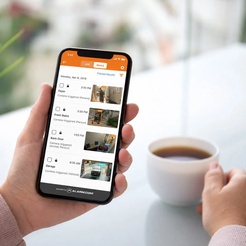 Spartanburg homeowner viewing security camera alerts on a smartphone using the Alarm.com mobile app.